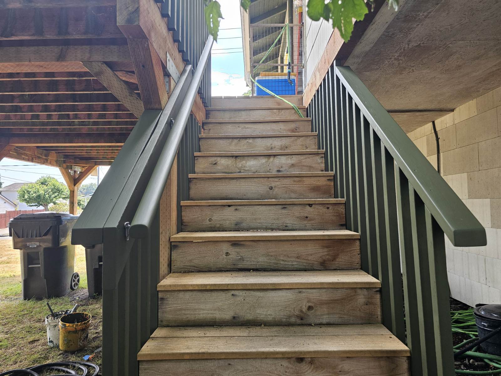 Rebuilt deck stairs with fresh stain and painted green railings